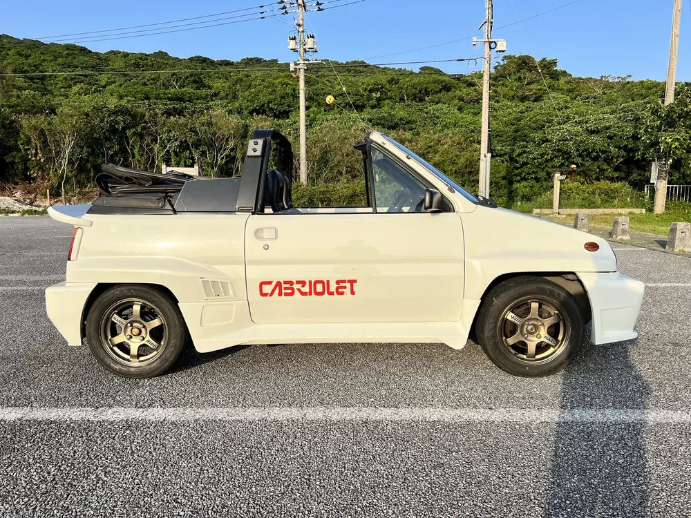 幌をたたんでオープンにした白いシティ カブリオレ