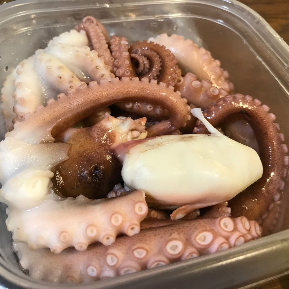 透明な容器に入った、タコの足のように見える食材