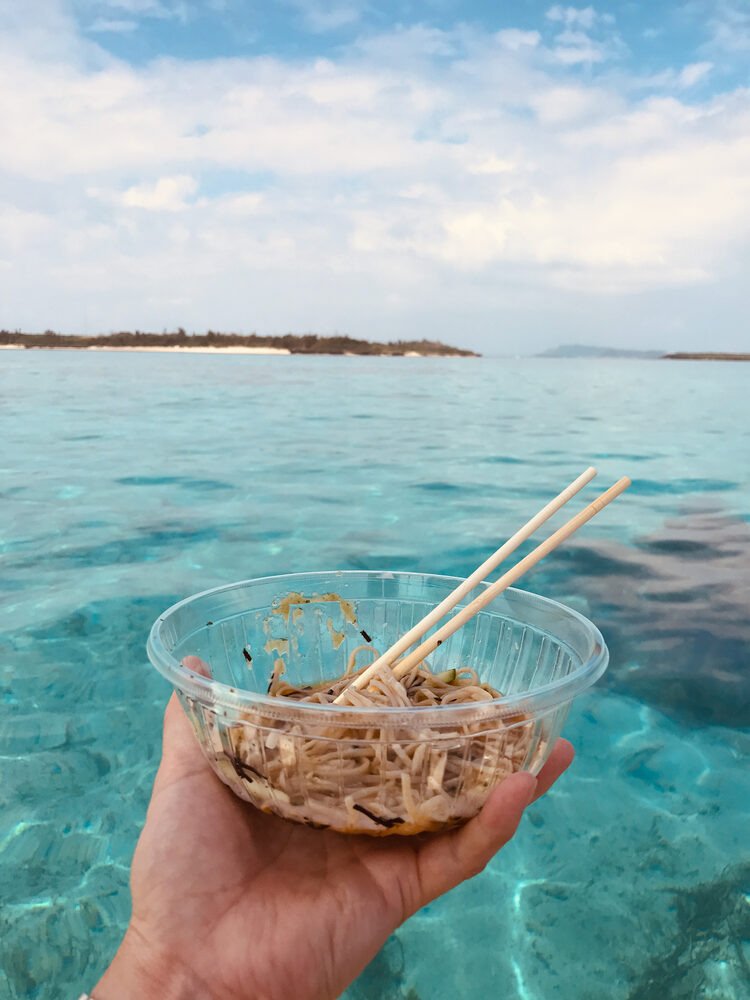 海の上で手に持った、そばの器と箸