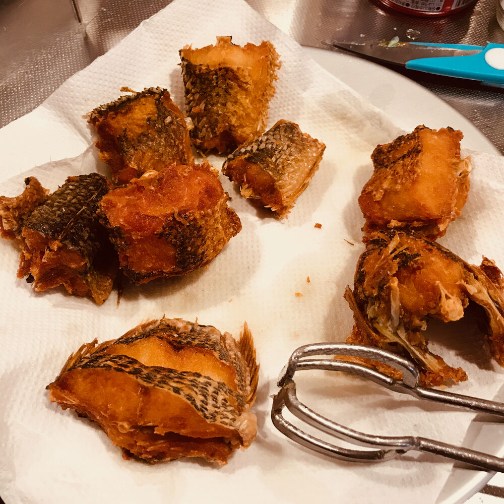 キッチンペーパーの上に並んだ揚げた魚
