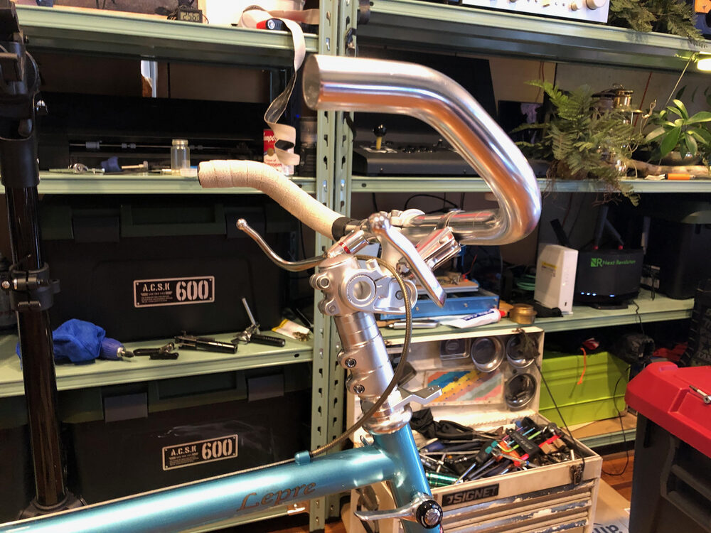 工具棚の前で撮った、水色の小さな自転車の銀色のドロップ型ハンドル
