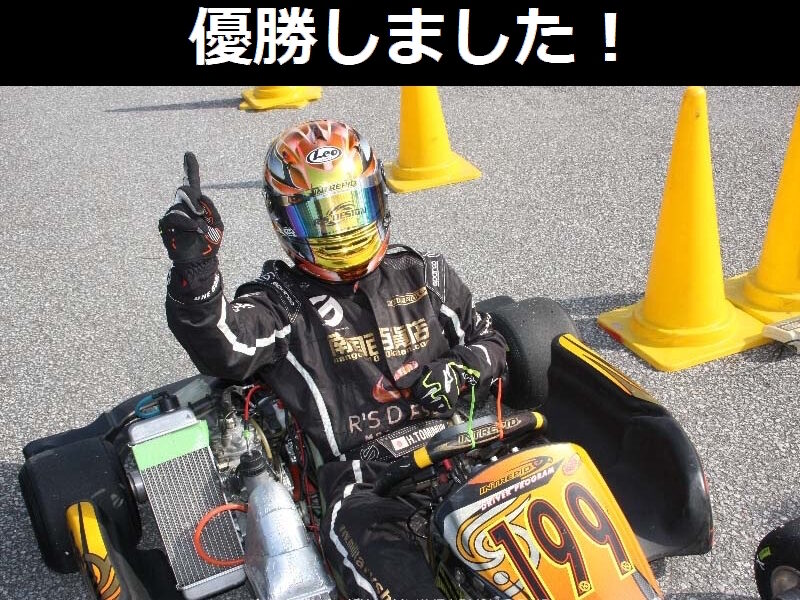 レーシングカートに乗って人差し指を立てる富村浩樹。上に「優勝しました！」の文字