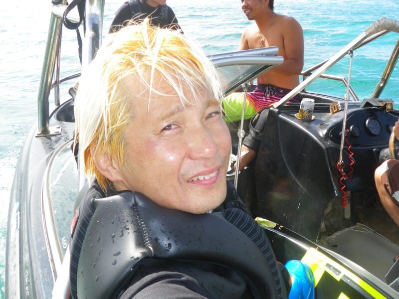 ボートの上でライフジャケット姿で笑う富村浩樹